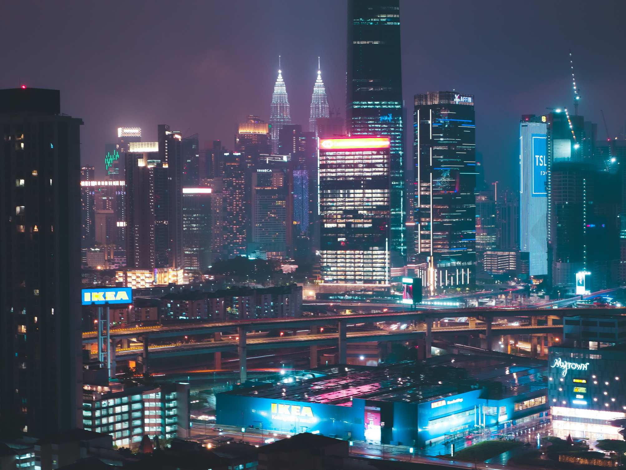 Urban street scene with high-rise buildings, vibrant night cityscape skyline